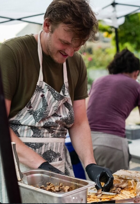 Raphaël prépare des champignons lors d’un événement sous un barnum.